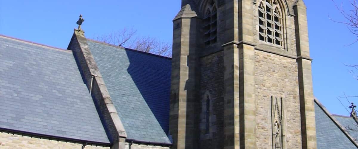 A church with a tall, pointed steeple and a clock tower.