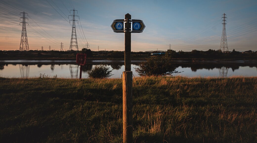 A signpost showing the Ribble Way walking trail along the River Ribble in Preston, UK at sunset