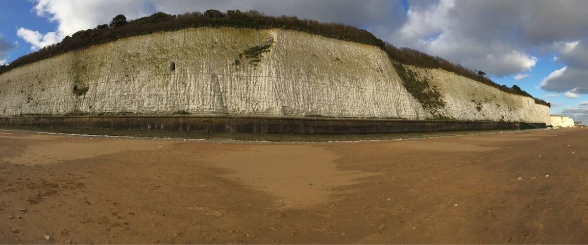 A large, flat-topped structure with a sandy foreground and a cloudy sky.