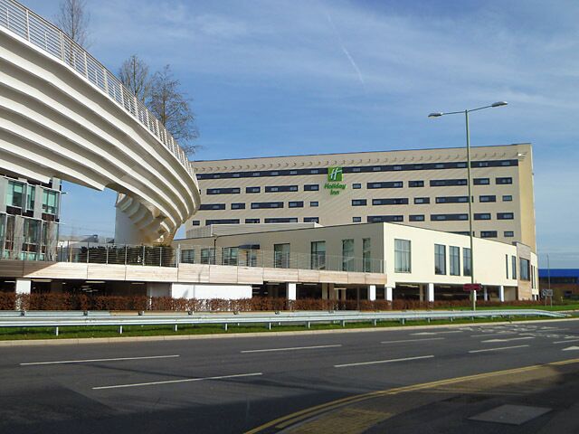 Hotel and footbridge, Winnersh, Data from Geograph: Description: In the foreground is the dual carriageway enterting the Winnersh Triangle business park. A new footbridge links the new Holiday Inn with the railway station. ICBM: 51.437417205, -0.889732676207 Location: (about 1 km from) near to Winnersh, Wokingham, Great Britain.