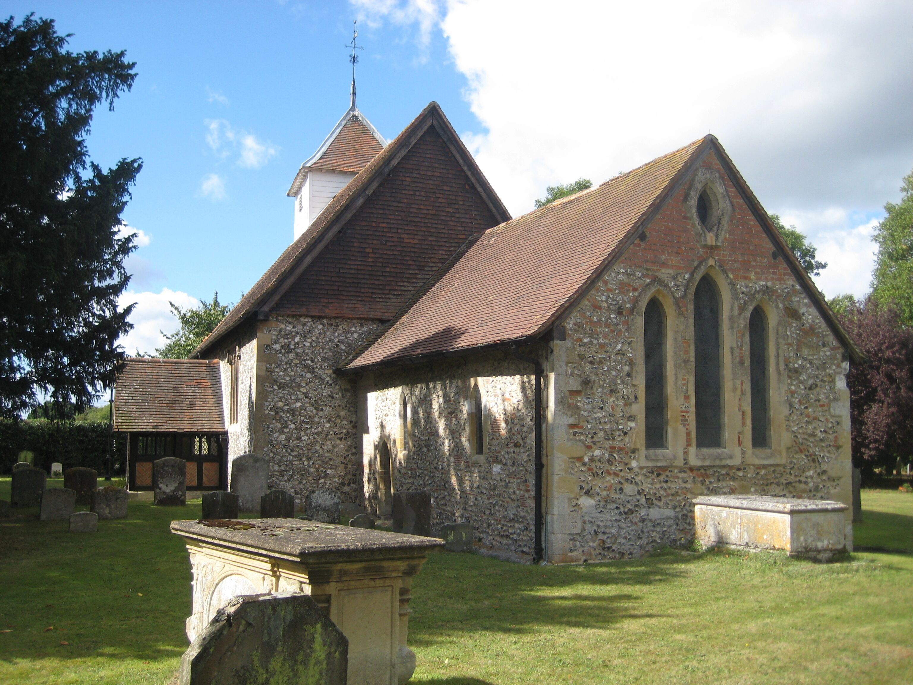 A small stone church with a tiled roof and a bell tower.