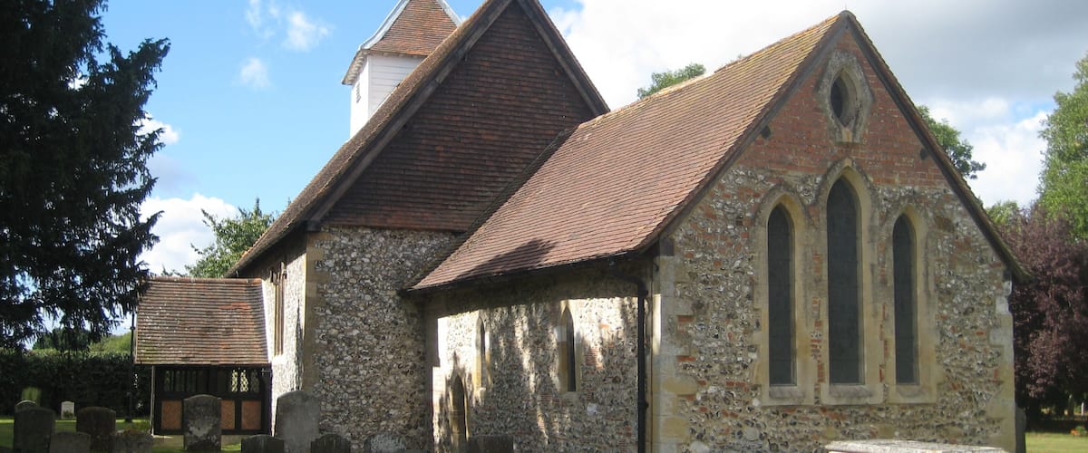 A small stone church with a tiled roof and a bell tower.