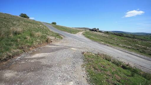 X Marks the Spot A minor road crosses a public footpath in a very open location.