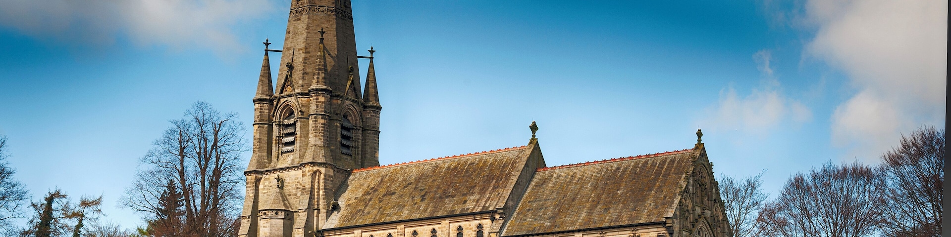 Una iglesia histórica con una aguja alta y arquitectura gótica.