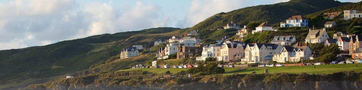 A coastal town with houses on a hillside, a sandy beach, and the sea.