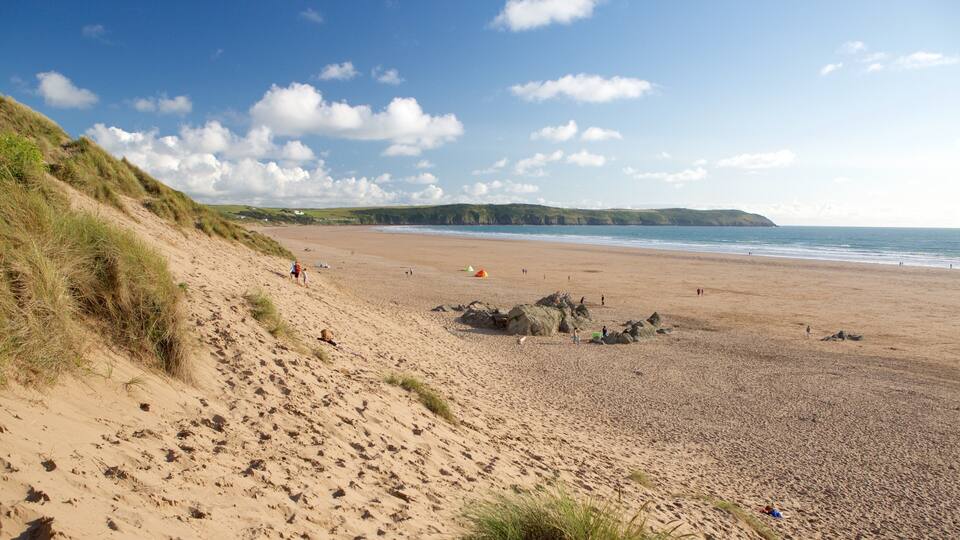 A sandy beach with dunes and a clear sky.