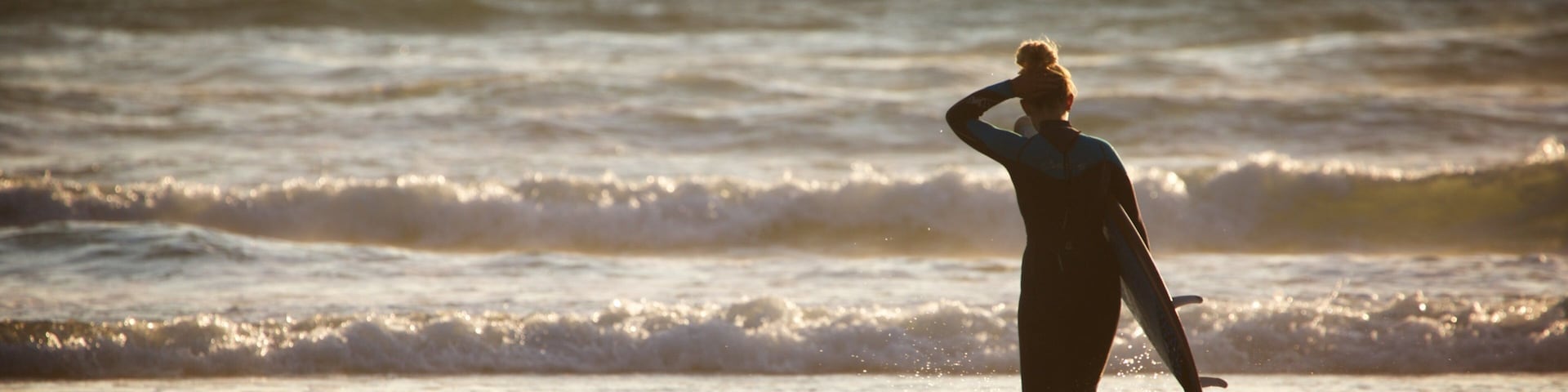 Woolacombe showing waves and surfing as well as an individual femail