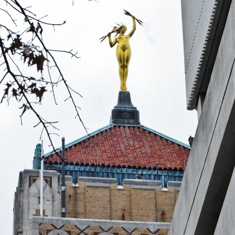 Miss Electra, Power Goddess !! 

This Gold Leafed Goddess wields her lightning bolts over the City of Birmingham from 20 stories high atop the Art Deco Alabama Power Building built in 1925. 

 Finding the right vantage point to take a picture is tricky and you will need a long lens. I caught her on a very overcast day and was really hoping to catch her with a dark blue clear sky. Maybe next time...

Electra stands on her tippy-toes to reach 23 feet and, although it is ungentlemanly of me to discuss, weighs 4,000 pounds. She was originally cast in bronze and then gold leafed.

Cleaned and re-gilded on her 70th birthday in 1996, The "Butt-Naked" Babe still looks as intoxicating as ever from her elusive perch. 

She has no affiliation with Greek Myth Electra, the vengeful and murderous daughter of King Agamemnon. But.... not sure I would want to cross her either way with those ominous bolts in hand.

33°31'4"N   86°48'44"W
#birmingham