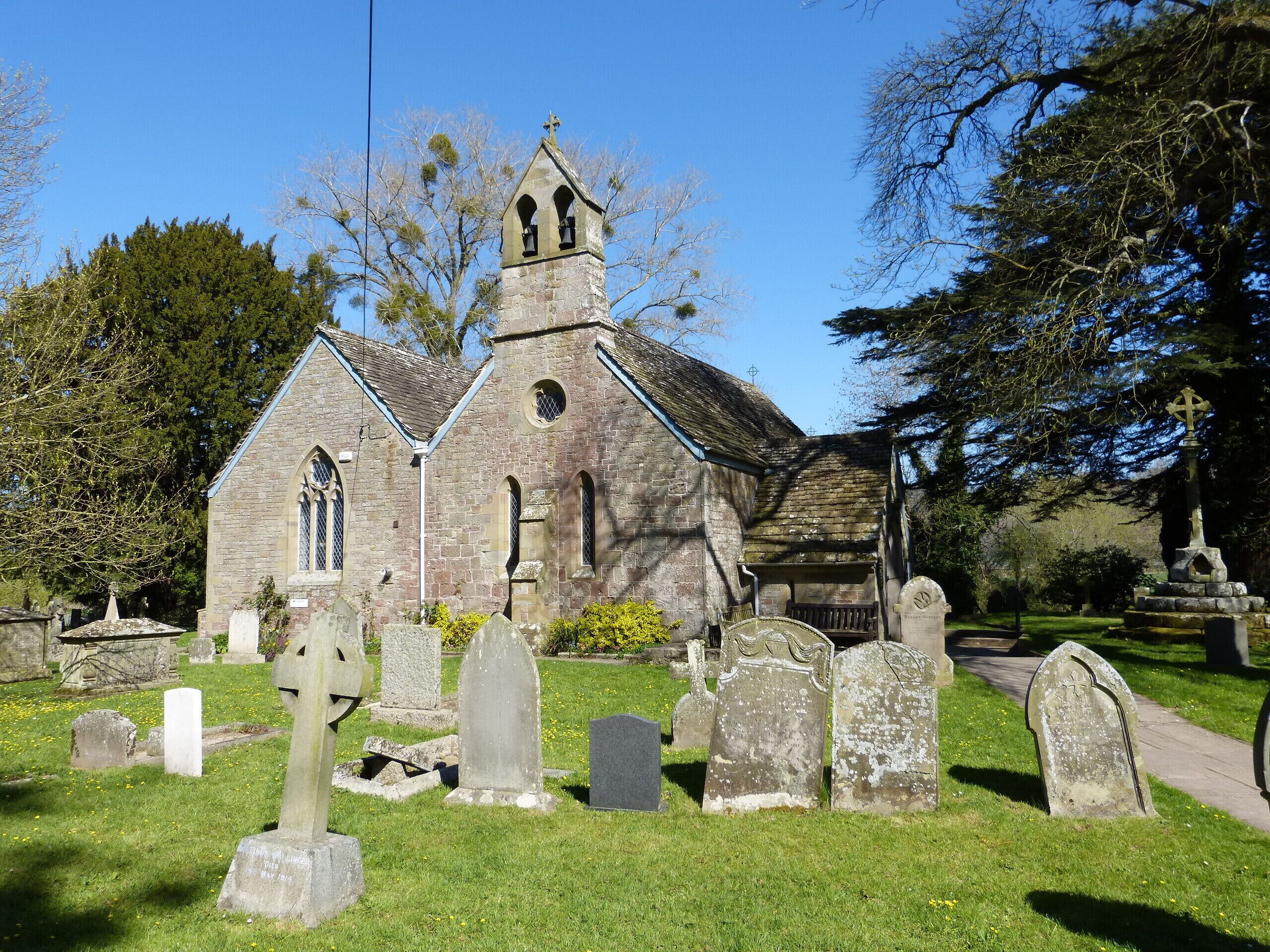 A church with a bell tower and a graveyard with headstones.