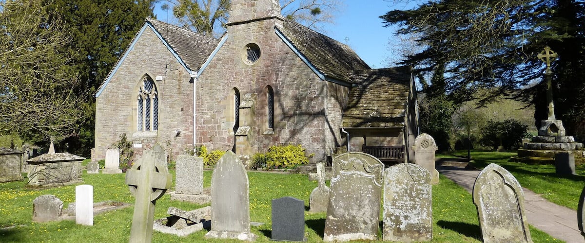 A church with a bell tower and a graveyard with headstones.