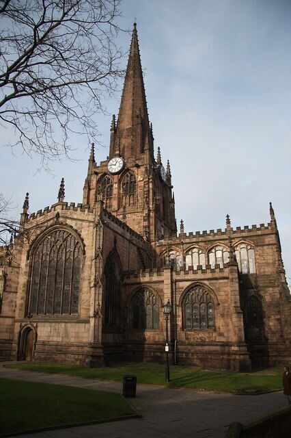 A large, historic church with a tall spire and large arched windows.
