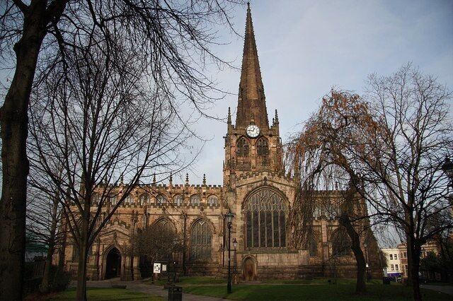 A historic church with a tall spire and a clock.