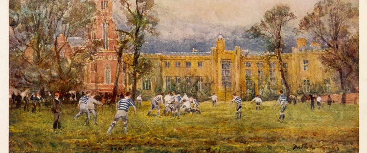 A historical building with a tower, surrounded by trees and a grassy field where people are playing a game.