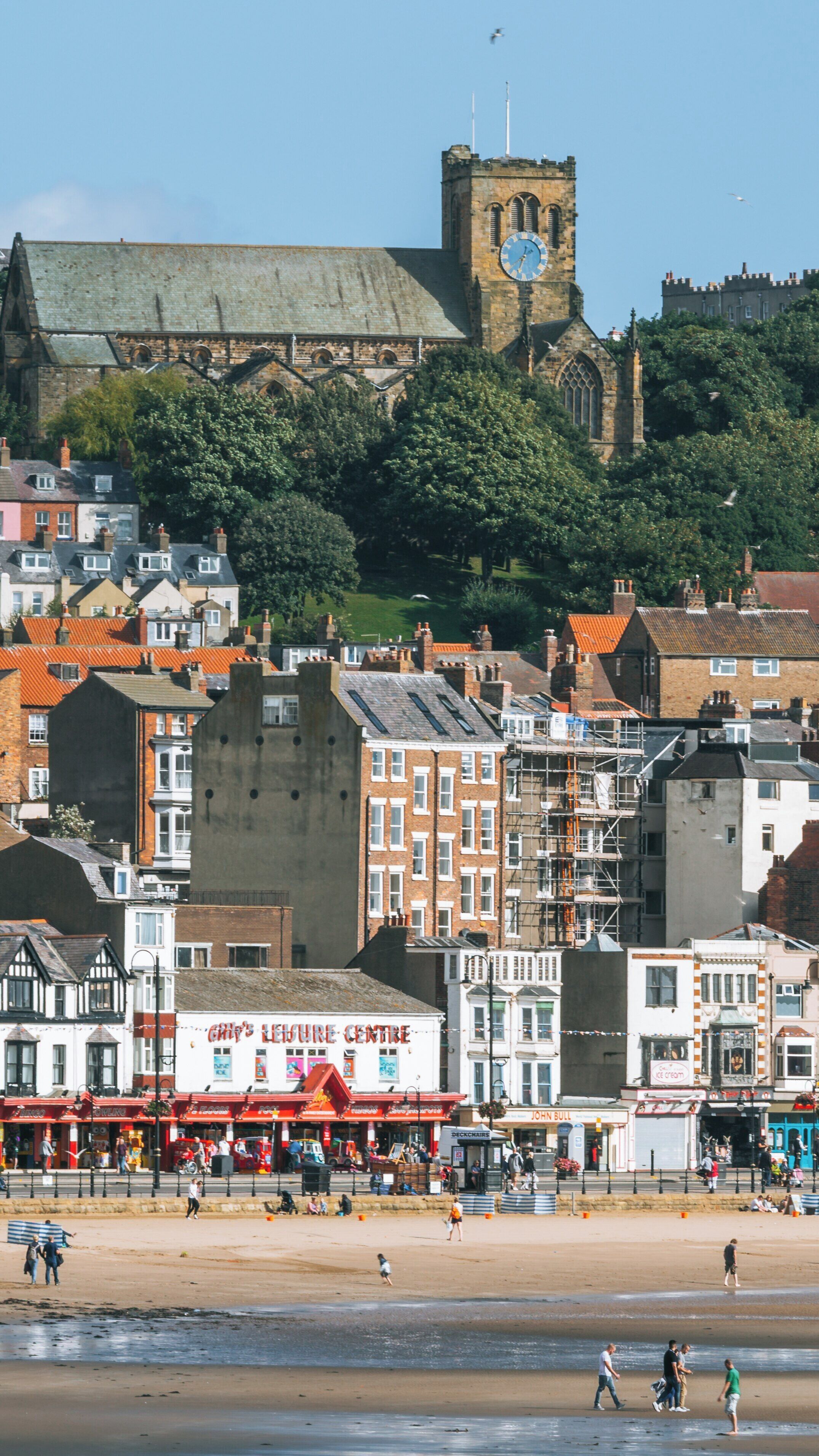 Enjoying South Bay Beach near Scarborough City Centre on a sunny day with families strolling and buildings rising in the background