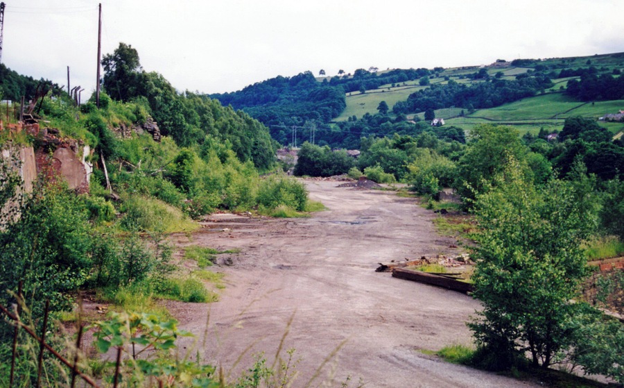 Site of former Deepcar station. View southward, towards Sheffield: ex-GCR Sheffield Victoria etc. - Penistone - Woodhead Tunnel - Manchester main line, electrified 6/54 but closed to through passenger trains 5/1/70, to goods 20/7/81; passenger services Sheffield - Deepcar - Barnsley Junction - Penistone ceased and line closed completely 16/5/83, but goods branch to Stocksbridge - hidden here behind bushes on the right, remains.