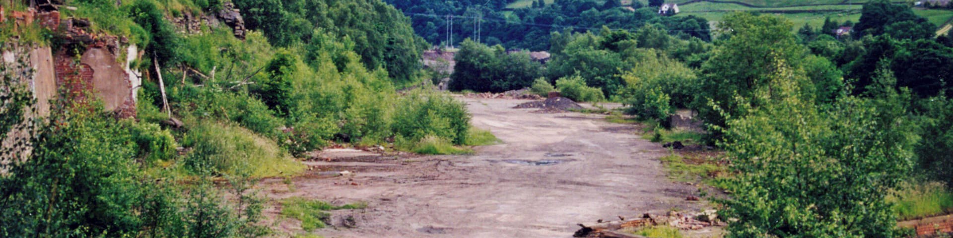 Site of former Deepcar station. View southward, towards Sheffield: ex-GCR Sheffield Victoria etc. - Penistone - Woodhead Tunnel - Manchester main line, electrified 6/54 but closed to through passenger trains 5/1/70, to goods 20/7/81; passenger services Sheffield - Deepcar - Barnsley Junction - Penistone ceased and line closed completely 16/5/83, but goods branch to Stocksbridge - hidden here behind bushes on the right, remains.