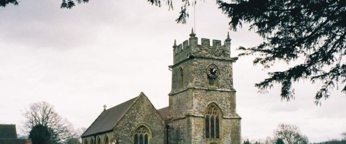 A church with a clock tower and a graveyard.