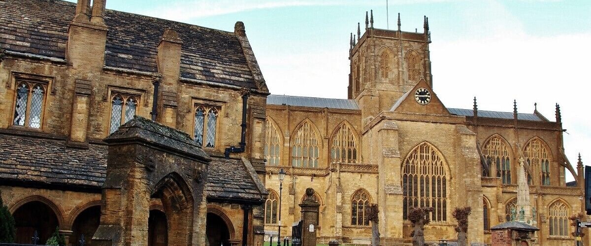 A historic stone building with arched windows and a clock tower.