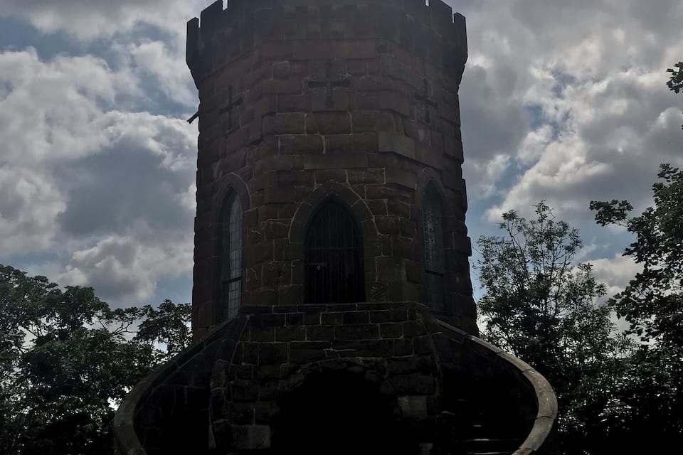 Una torre de pedra amb una escala en espiral que mena a una porta.