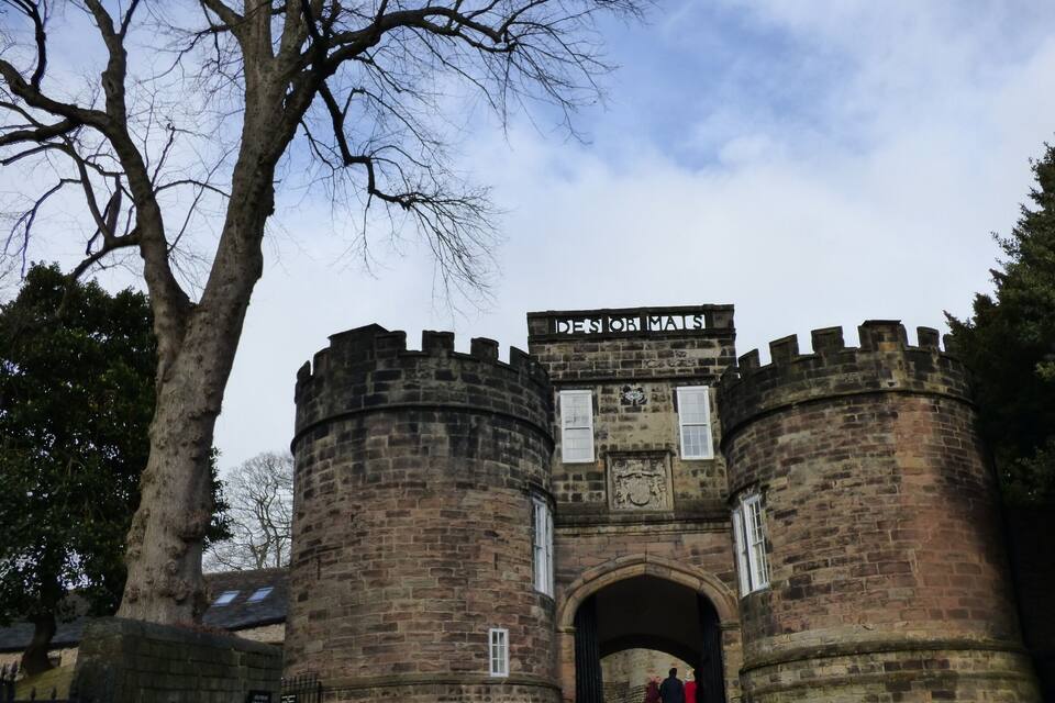 A historic stone gatehouse with two round towers and a central archway.