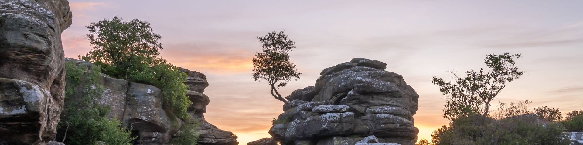 A rocky landscape with layered rock formations and sparse vegetation.