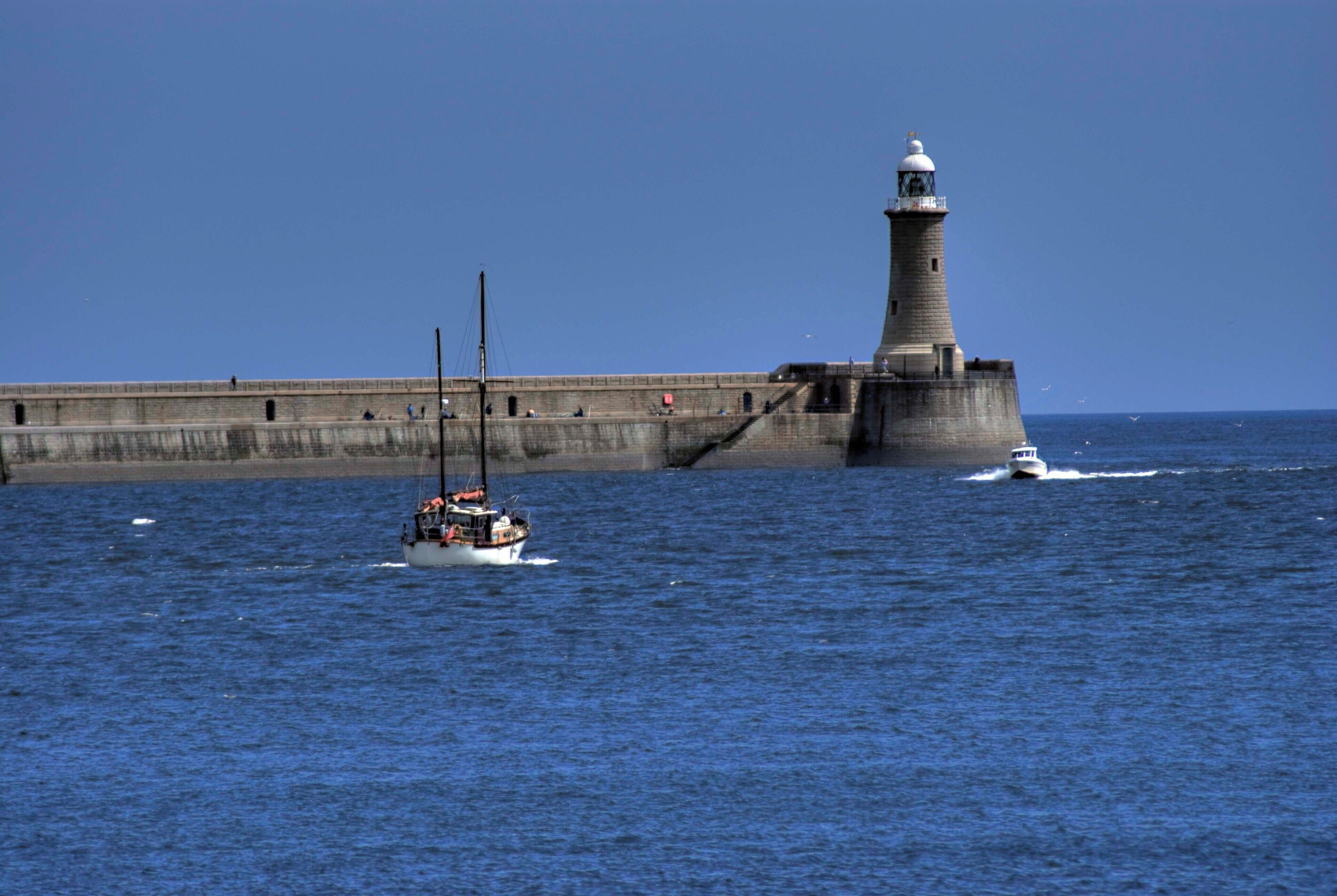 A lighthouse and a boat on the water.