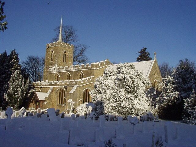 A church with a tall tower and a snow-covered landscape.