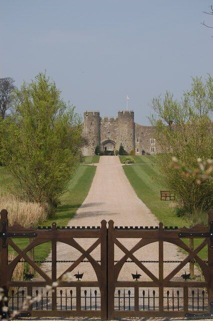A castle gate, a pathway, and a lawn leading to a castle.