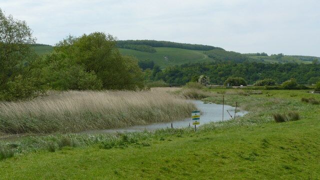 River Arun From the Edge of the Flood Plain A bend in the River Arun, as it winds out across the flood plain. In the foreground, the notices warn of strong currents and slippery river banks.