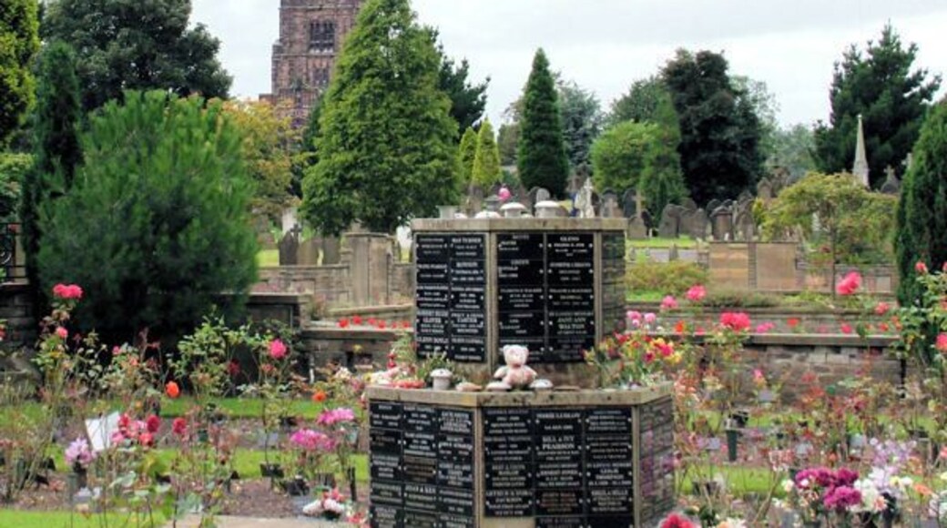 One of the cremation Memorials at Stockport Cemetery St. George's Church, can be seen through the trees.