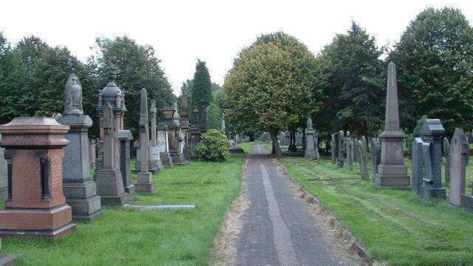 A cemetery with rows of headstones and a central path.