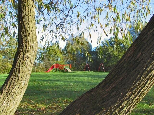 Park and Rides. Children's swings and slides in parkland within a housing estate off Bramhall Moor Lane,Stockport.