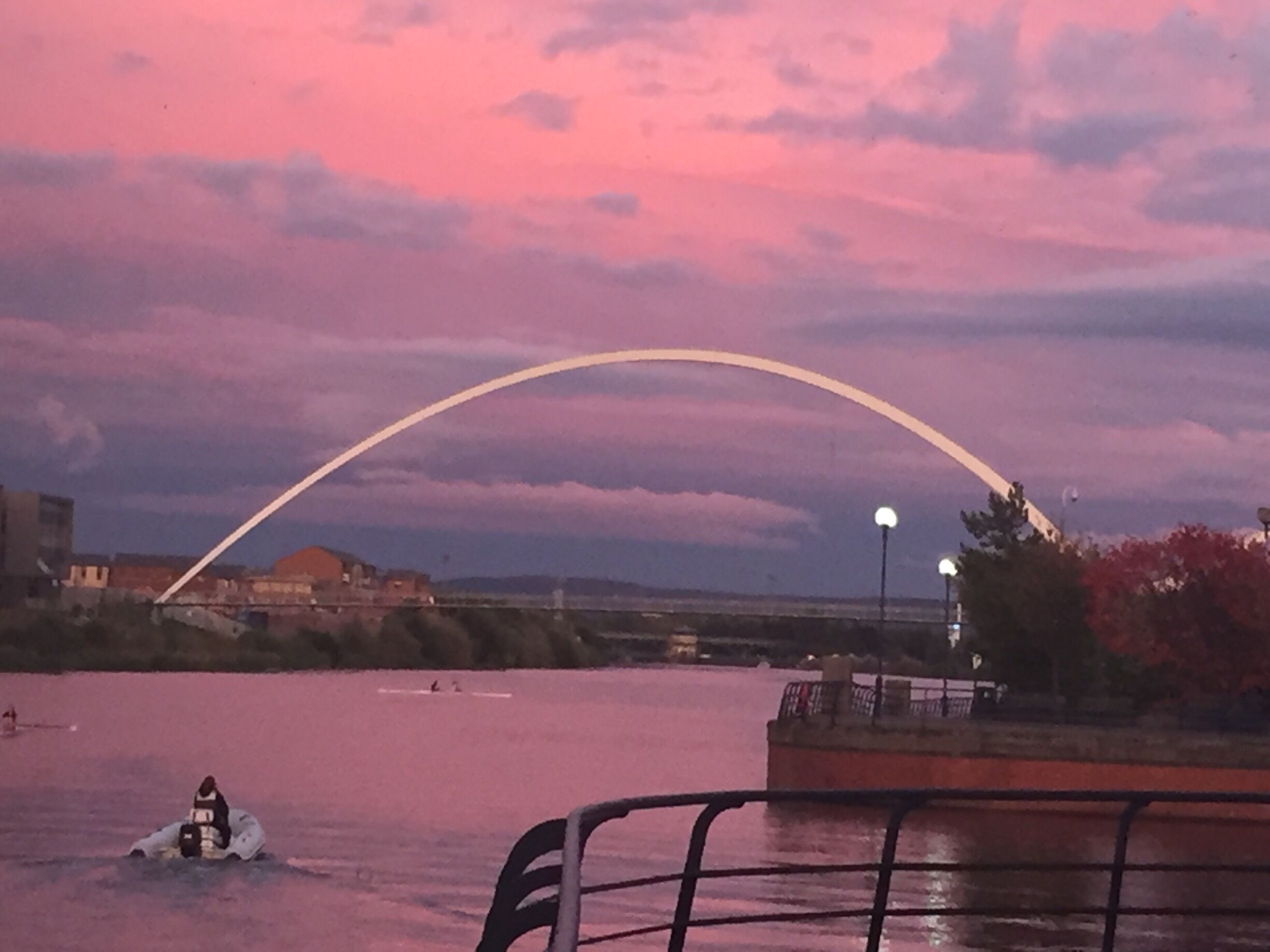 A river with a bridge in the background and a person in a kayak.