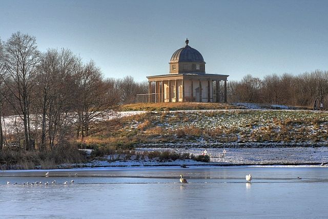Temple of Minerva Dating back to 1756 and built in the Ionic style. The folly has been recently restored but still has builder's safety fencing around. Seen here from across the newly excavated lake at Hardwick Hall Country Park on a freezing winter's day.