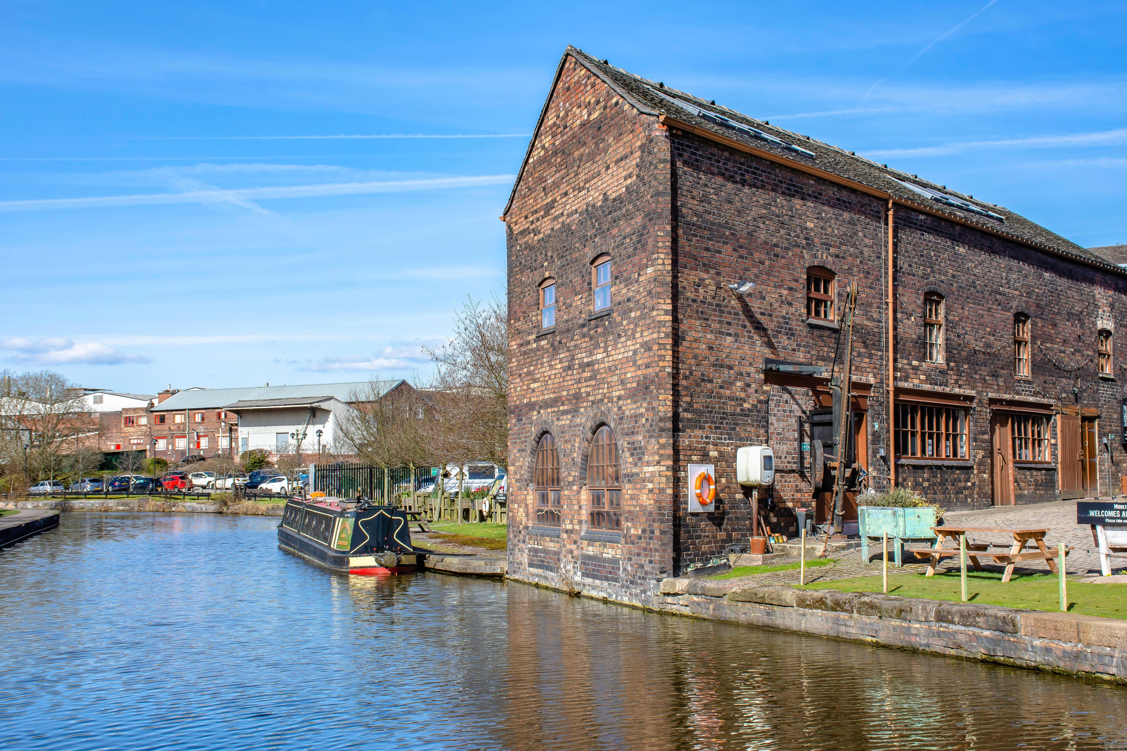 PH4208 Stoke on Trent,Staffordshire/UK-04.14.2018:Narrowboat moored near old pottery factory on bank of Trent and Mersey canal.Historic industrial complex.