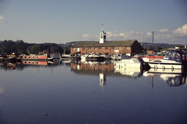 A harbor with boats, a clock tower, and a brick building.
