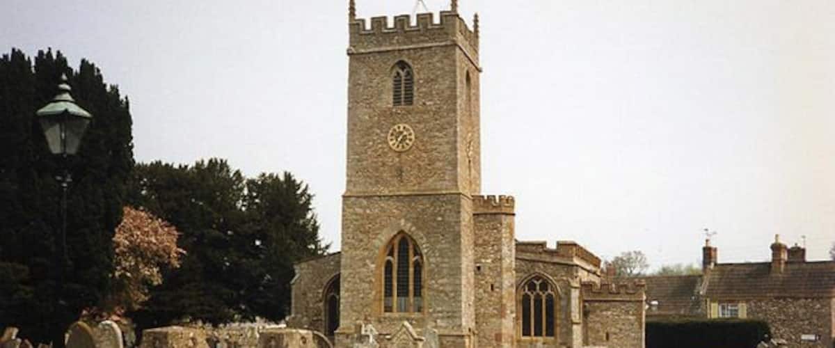 A stone church with a tall tower and arched windows.