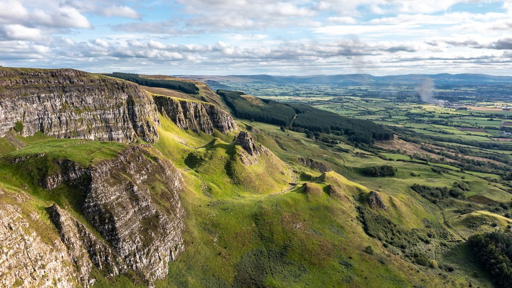 Eine zerklüftete Landschaft mit steilen Klippen und sanften Hügeln.