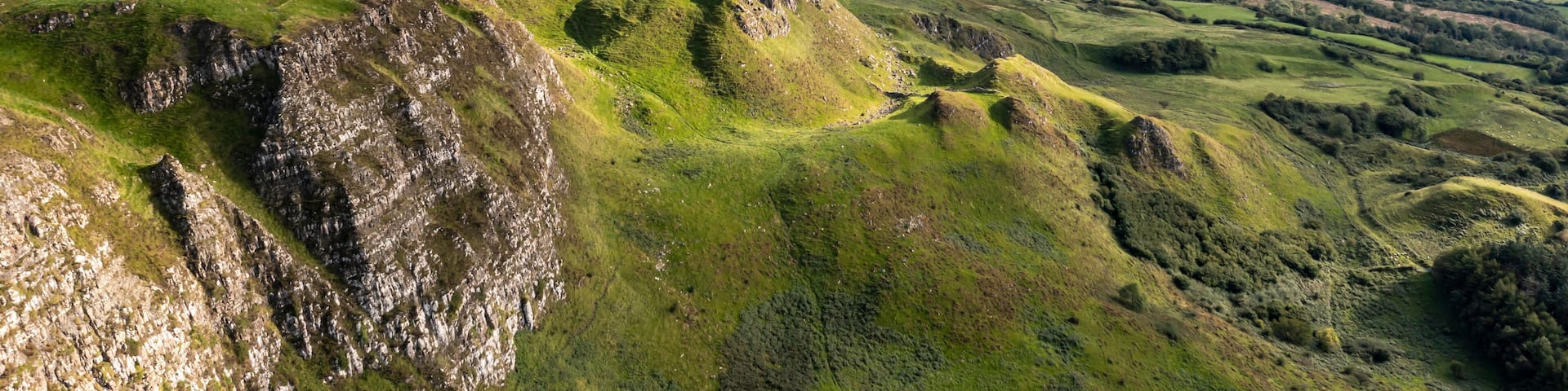 A rugged landscape with steep cliffs and rolling hills.