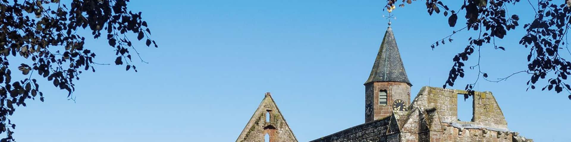 An old stone church with a clock tower and arched windows.