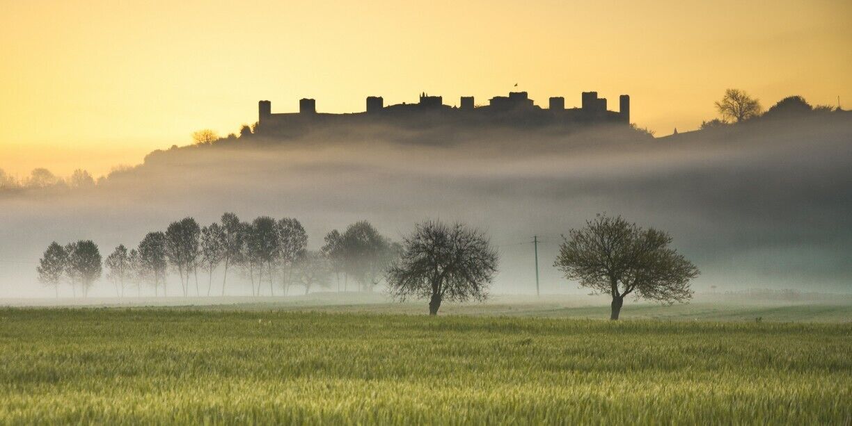 #TroveOn
Yes, Monteriggioni just might be the quintessential walled medieval village in Tuscany. It's small enough to perhaps be called "cute" but you won't catch me using this term.

Monteriggioni began as a border fortress built on a round hill by Sienna against the Florentines. It is famous for the intact defensive structure that held up against repeated Florentine attacks in the 11th century; its 10 meter high walls and 14 towers can still be seen for miles around. Monteriggioni has been featured in movies as a typical medieval village.

The village is slightly elliptical in shape with two gates (a third has been plugged). The major gate tourists will use when coming from the parking lot, Porta Franca, owes its name to the Via Francigena--Monteriggione was a major stop on the pilgrimage trail from Cantebury to Rome. The Romanesque Church of Santa Maria Assunta will offer assistance with housing for modern pilgrims traveling the Francigena pilgrimage route.

Monteriggioni was a sleepy village of farmers and sheep herders as late as the 1960's. Today it exists entirely for tourists and pilgrims. You'll find wine shops, a tasting room, restaurants and hotels in the small village. This is not neccessarily a disadvantage, although some times it's nice to see some locals puttering about once in a while.

Where is Monteriggioni?

Monteriggioni is located in the province of Siena, 14km to the northwest of Siena (54km from Florence). While it can be done as a day trip from Siena, you might be better off staying the night--Monteriggioni is much more evocative when the tourists leave late in the afternoon and you can sit in a courtyard sipping a glass of Chianti. Monteriggioni is surrounded by vineyards, and is known for its wine production.

