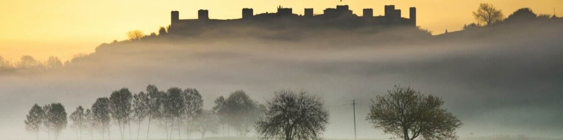 #TroveOn
Yes, Monteriggioni just might be the quintessential walled medieval village in Tuscany. It's small enough to perhaps be called "cute" but you won't catch me using this term.
Monteriggioni began as a border fortress built on a round hill by Sienna against the Florentines. It is famous for the intact defensive structure that held up against repeated Florentine attacks in the 11th century; its 10 meter high walls and 14 towers can still be seen for miles around. Monteriggioni has been featured in movies as a typical medieval village.
The village is slightly elliptical in shape with two gates (a third has been plugged). The major gate tourists will use when coming from the parking lot, Porta Franca, owes its name to the Via Francigena--Monteriggione was a major stop on the pilgrimage trail from Cantebury to Rome. The Romanesque Church of Santa Maria Assunta will offer assistance with housing for modern pilgrims traveling the Francigena pilgrimage route.
Monteriggioni was a sleepy village of farmers and sheep herders as late as the 1960's. Today it exists entirely for tourists and pilgrims. You'll find wine shops, a tasting room, restaurants and hotels in the small village. This is not neccessarily a disadvantage, although some times it's nice to see some locals puttering about once in a while.
Where is Monteriggioni?
Monteriggioni is located in the province of Siena, 14km to the northwest of Siena (54km from Florence). While it can be done as a day trip from Siena, you might be better off staying the night--Monteriggioni is much more evocative when the tourists leave late in the afternoon and you can sit in a courtyard sipping a glass of Chianti. Monteriggioni is surrounded by vineyards, and is known for its wine production.