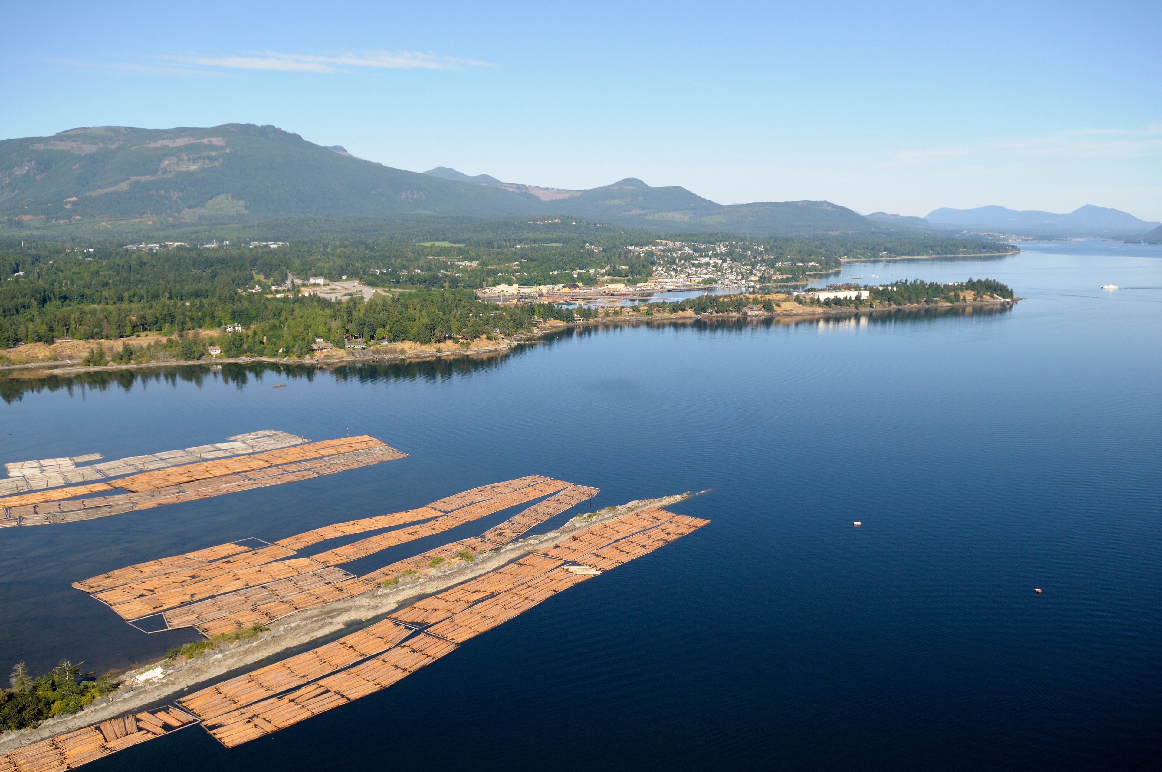Log booms stored in the Shoal Islands, Chemainus River Estuary, Chemainus Valley. Vancouver Island aerial photography, British Columbia, Canada.
