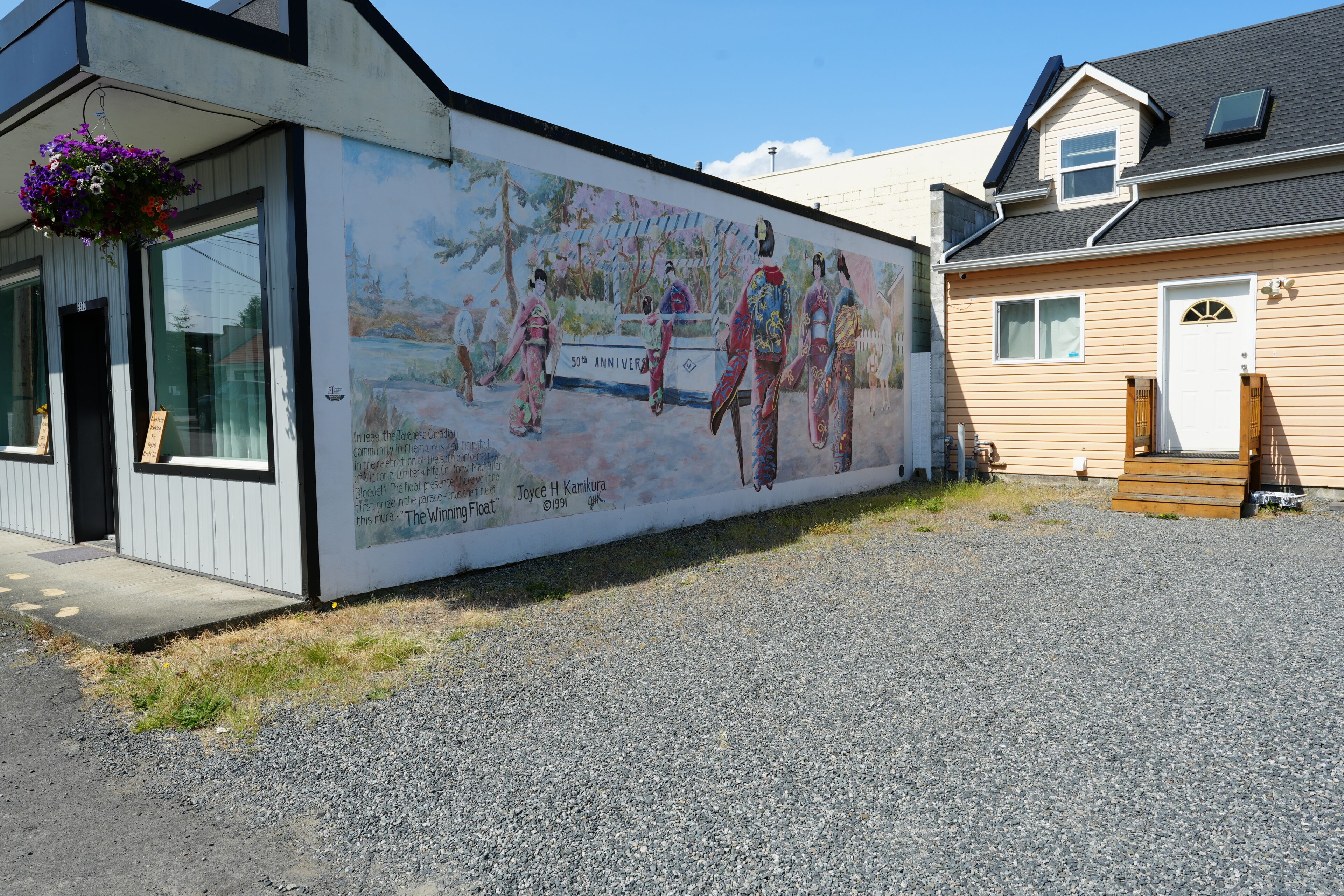 A building with a mural depicting historical figures and a sign indicating a 50th anniversary.
