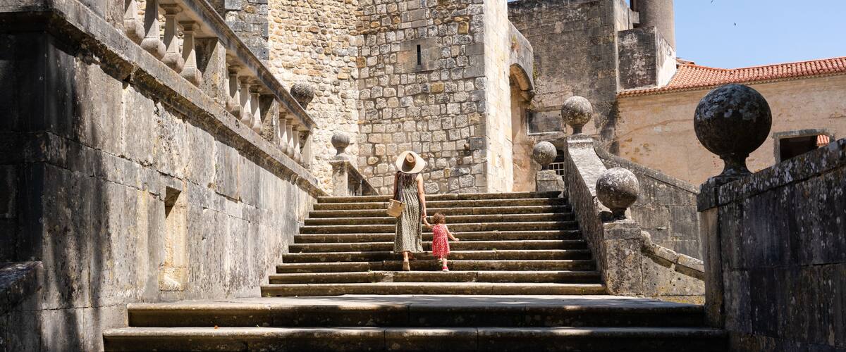 A stone staircase leading up to a historic building with a tower.