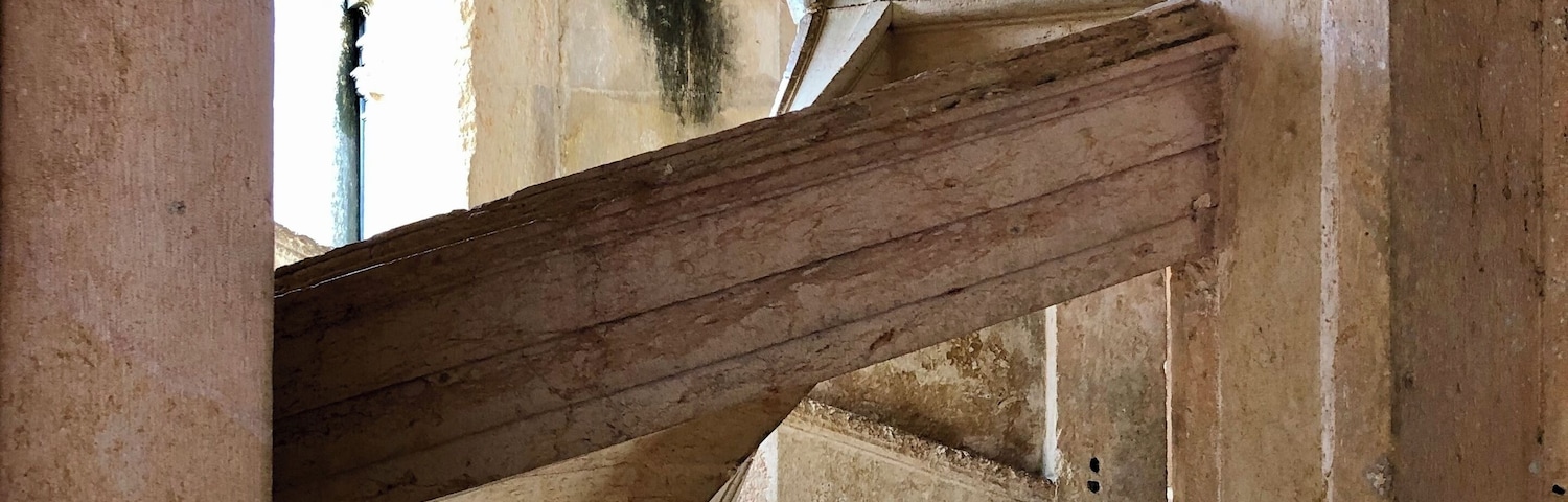 Uma estrutura antiga de pedra com arcos curvos e colunas.