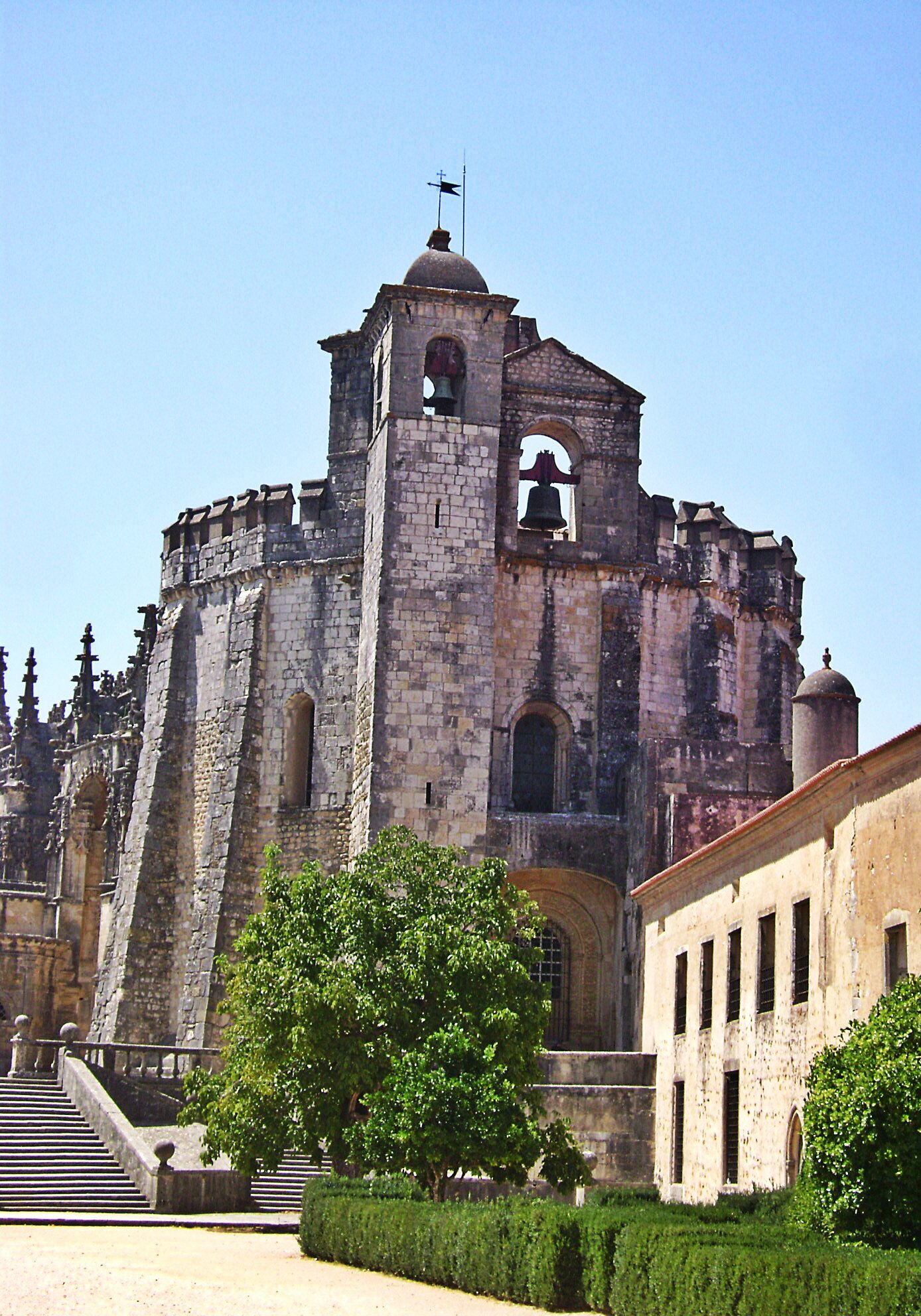 A historic stone church with a bell tower and a large arched doorway.