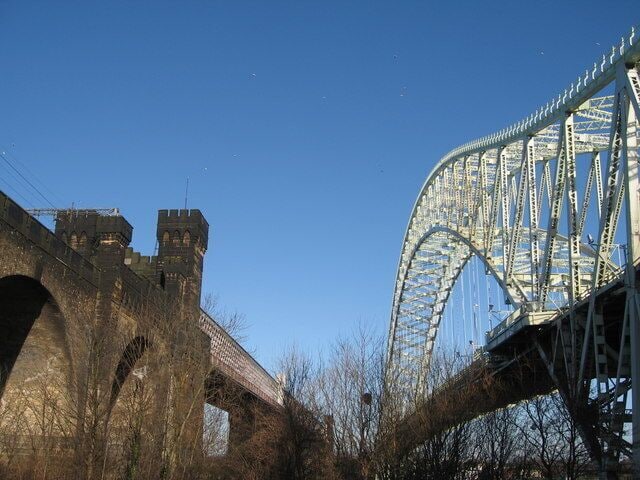 A roller coaster track and an old stone bridge.