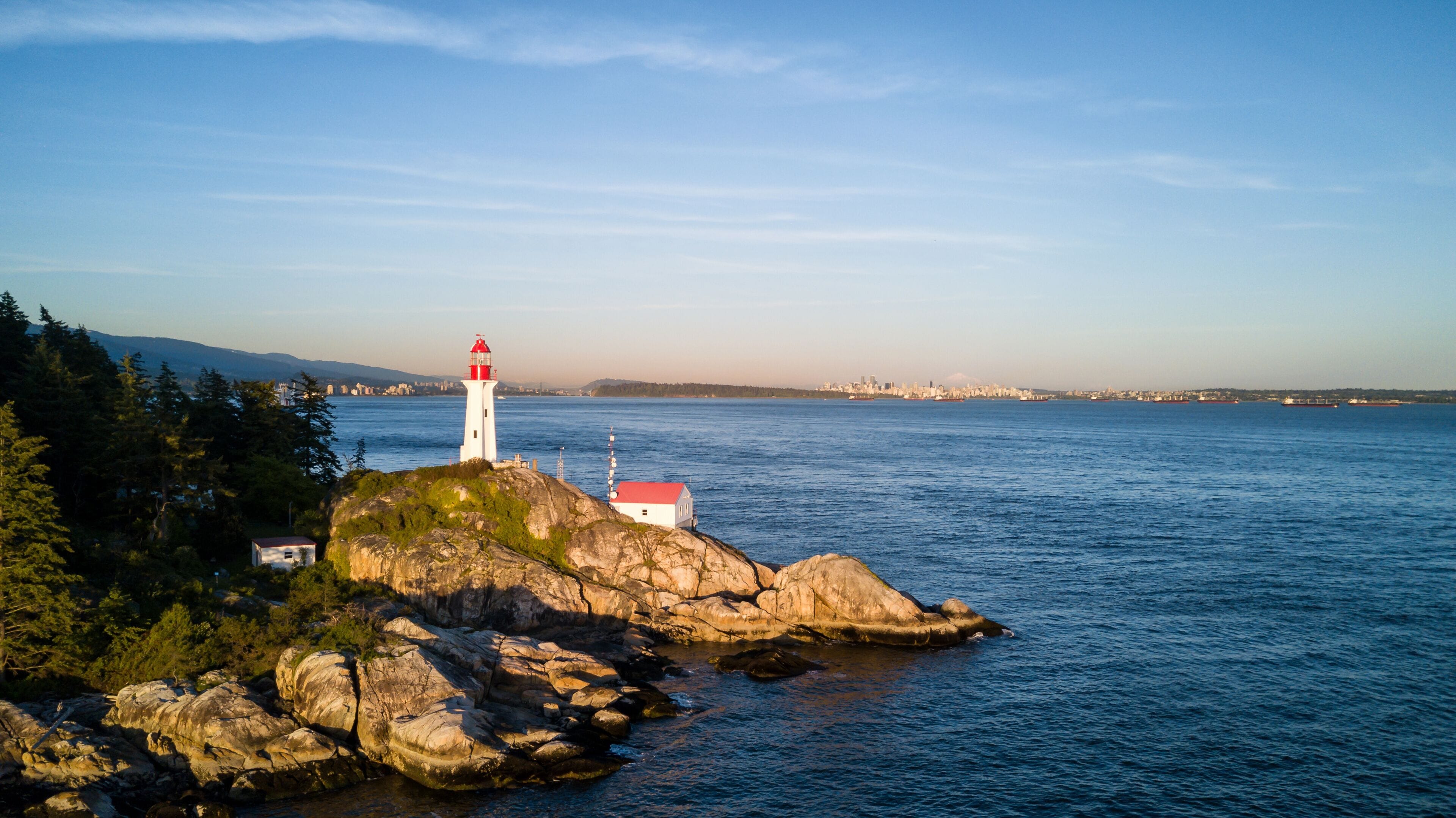Aerial view of the Light House on a rocky shore. Taken in Lighthouse Park, West Vancouver, British Columbia, Canada, during a sunny sunset.