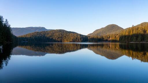 Beautiful and Vibrant panoramic view of a lake surounded by Canadian Mountain Landscape during sunset. Taken in White Pine Beach, Port Moody, Vancouver, British Columbia, Canada. Panorama